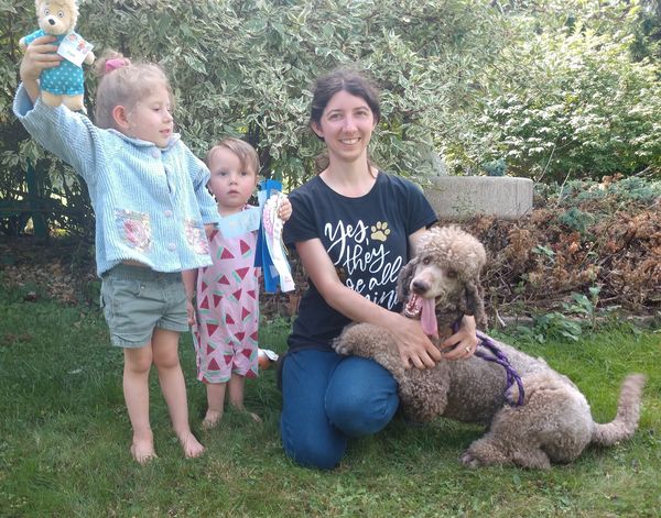 Jillian with her 2 young kids and Locket, a silver beige Standard Poodle with a big goofy grin.