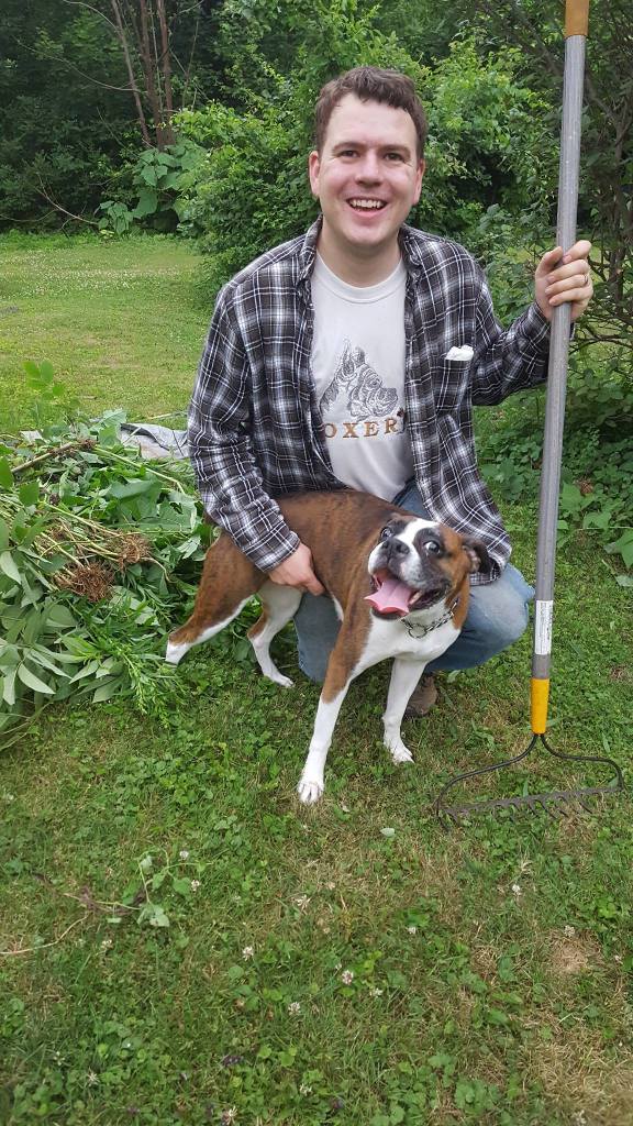 Tim taking a break from yardwork with his smiling Boxer, Brandi